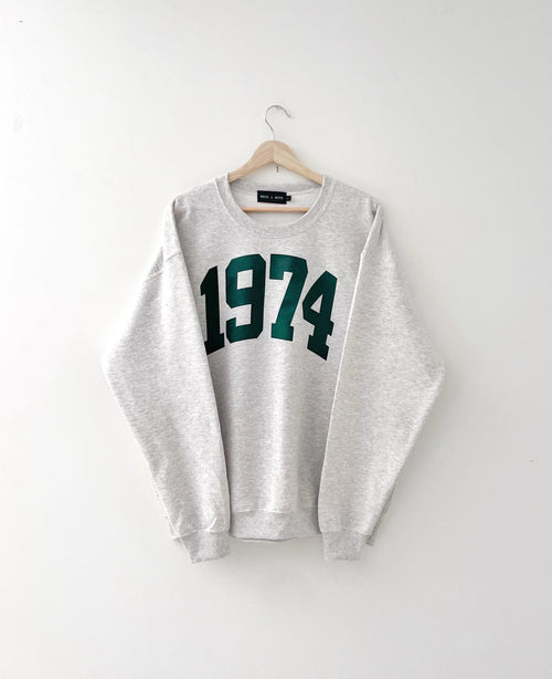 Grey sweatshirt with '1974' printed in green on a white background, 1974, 74, 50, birthday gift, 70s, cozy, sweatshirt, gift ideas