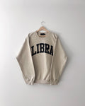 Beige sweatshirt with 'LIBRA' text on a hanger against a white background, gift ideas, zodiac, astrology, birthday, cozy, libra