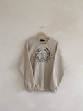 Beige sweatshirt with a crab design on a hanger against a white wall, cancer zodiac, zodiac, trendy