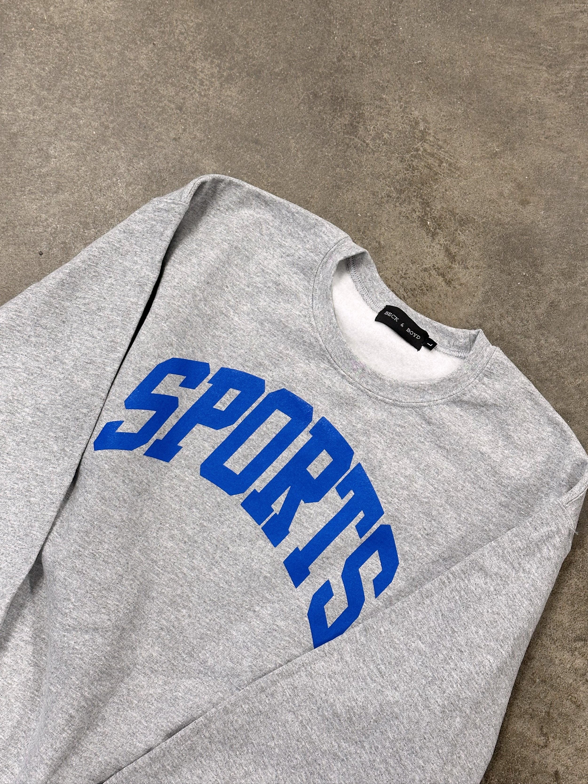 Gray sweatshirt with blue 'SPORTS' text on a concrete floor, Blue jays, Toronto Maple leafs, Sporty GF, Sporty Chic, Athletic, Sports, Baseball, Hockey, cozy
