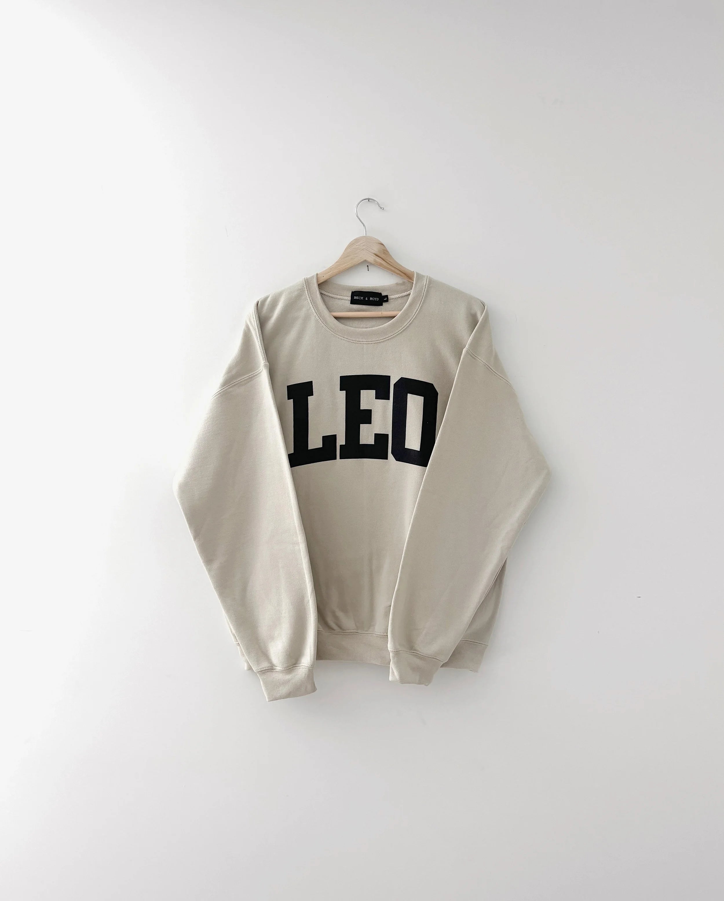 Beige sweatshirt with 'LEO' text on a white background, zodiac, gift ideas, astrology, lion