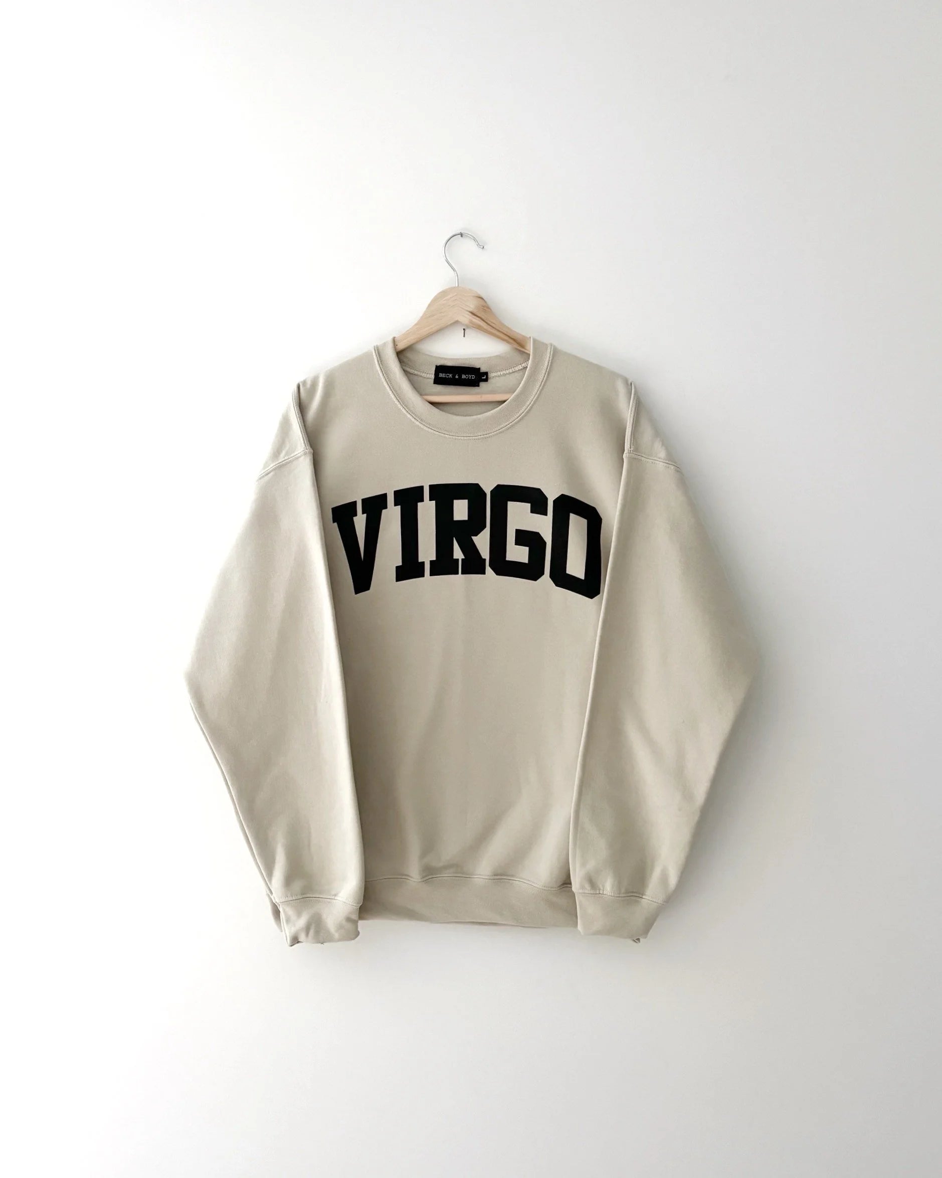 Beige sweatshirt with 'VIRGO' text on a white background, virgo, zodiac, astrology, virgo sweater, cozy